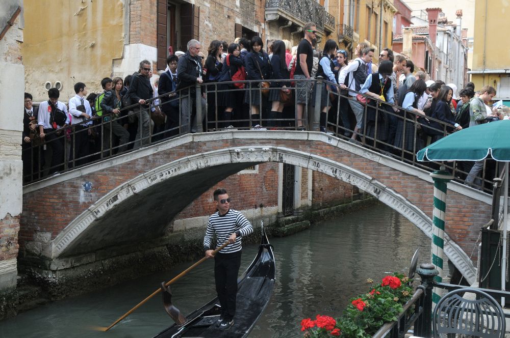 Tourists walking over the crowded the bridge in Venice, Italy