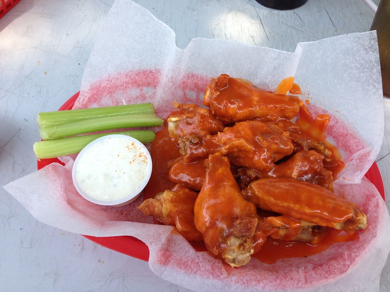 Basket of buffalo wings with a side of celery and blue cheese dressing