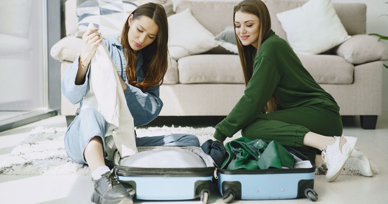 Girls packing their travel suitcase in comfortable clothes