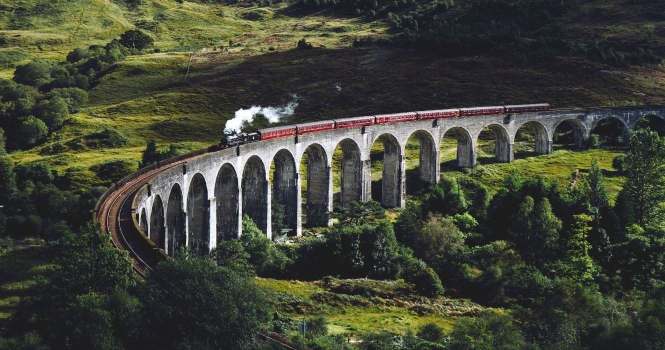 A steam train locomotive traveling along the Glenfinnan Viaduct, Glenfinnan, United Kingdom
