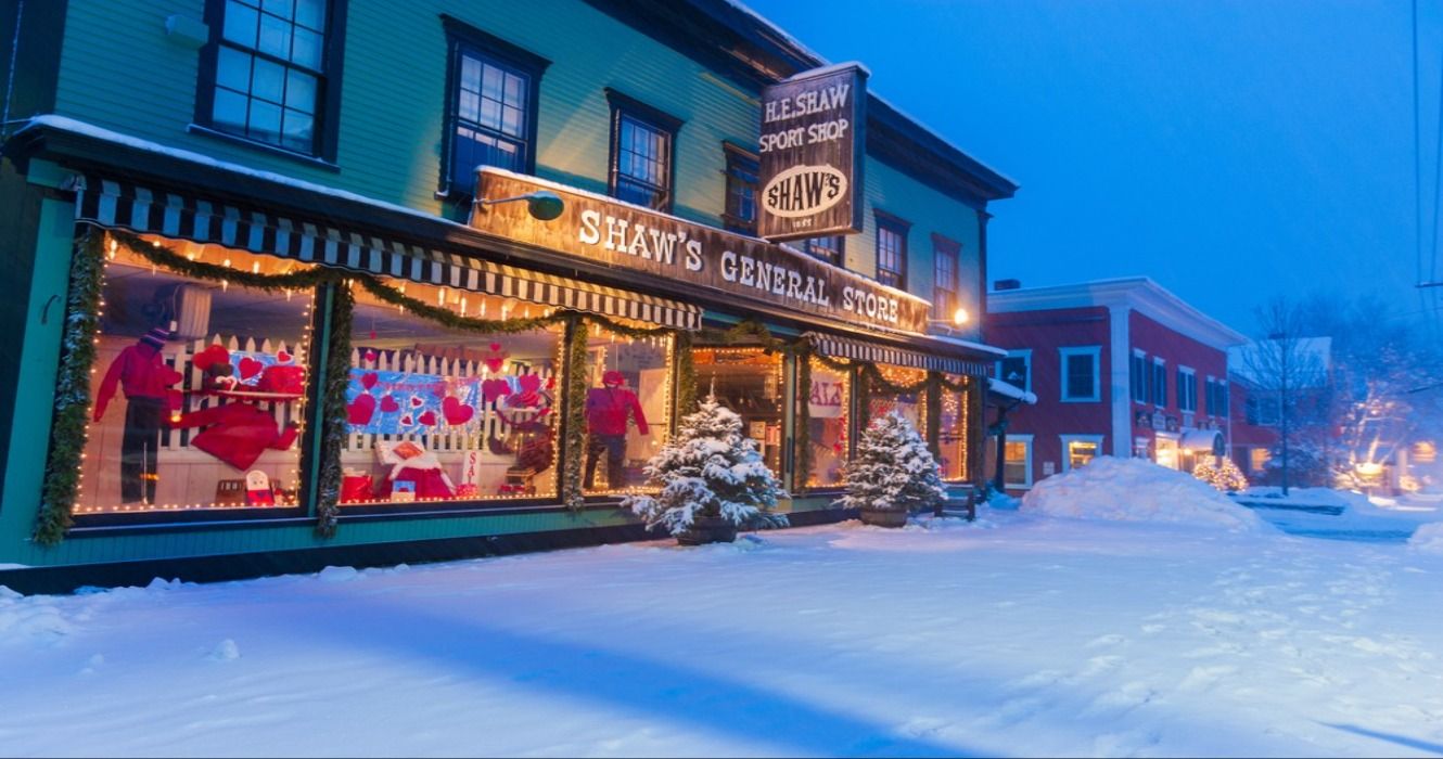 Shaws General Store at night in the winter during the Christmas holidays on a snowy street covered in snow in Stowe, Vermont, New England, USA