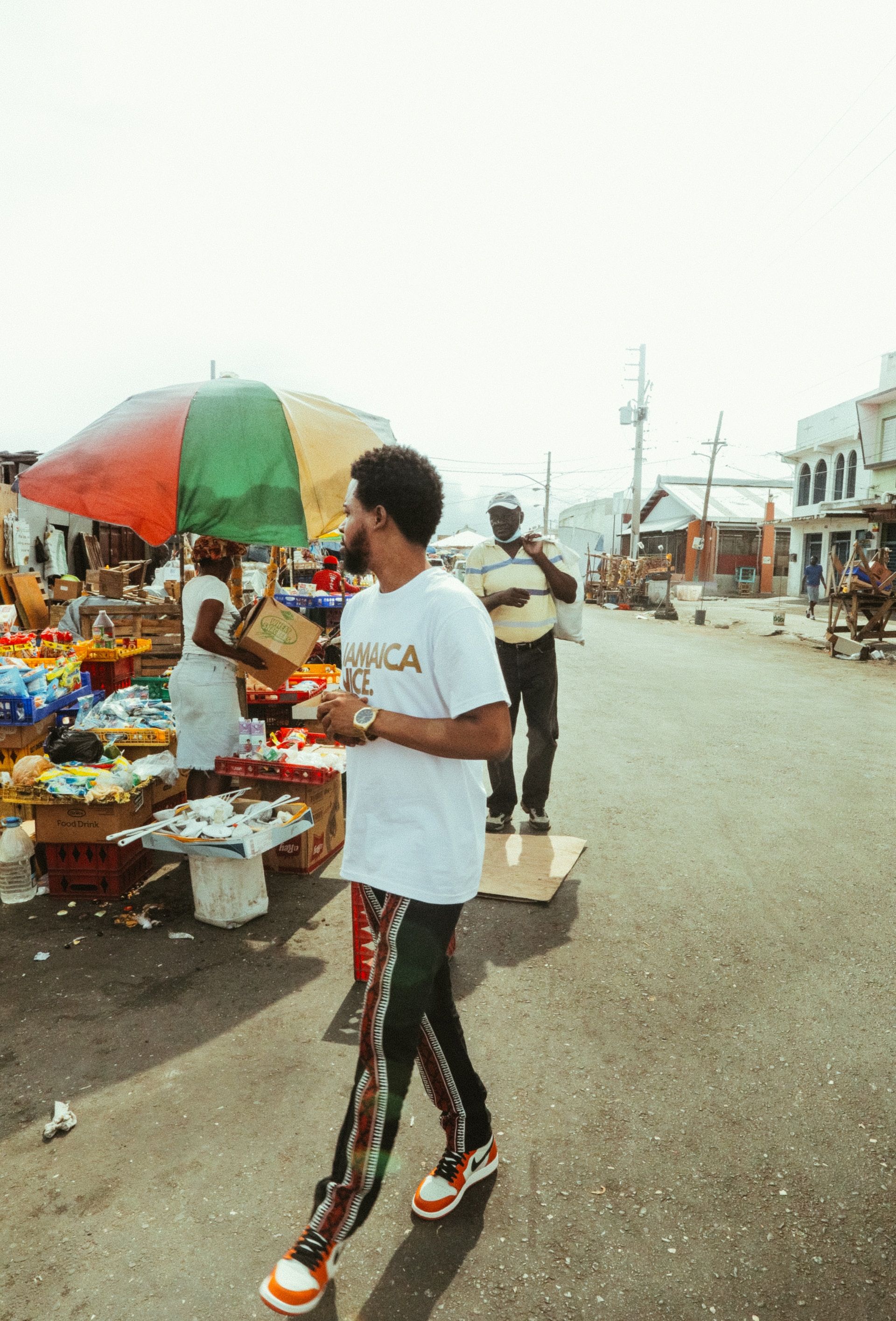 man walking among street produce vendors in Kingston, Jamaica