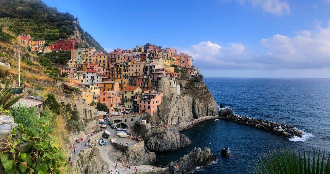 Beautiful view of the stacked houses at Manarola, Cinque Terre with a bright blue sky and the deep blue sea in the background