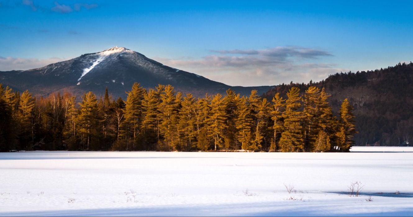 Whiteface Mountain peak (one of the High Peaks in the Adirondack Mountains, aka the Adirondacks) seen from the frozen Paradox Bay, Lake Placid, Upstate New York, NY, USA