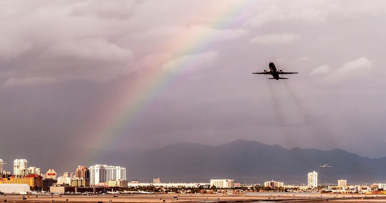 Airplane flying over Las Vegas airport with a rainbow