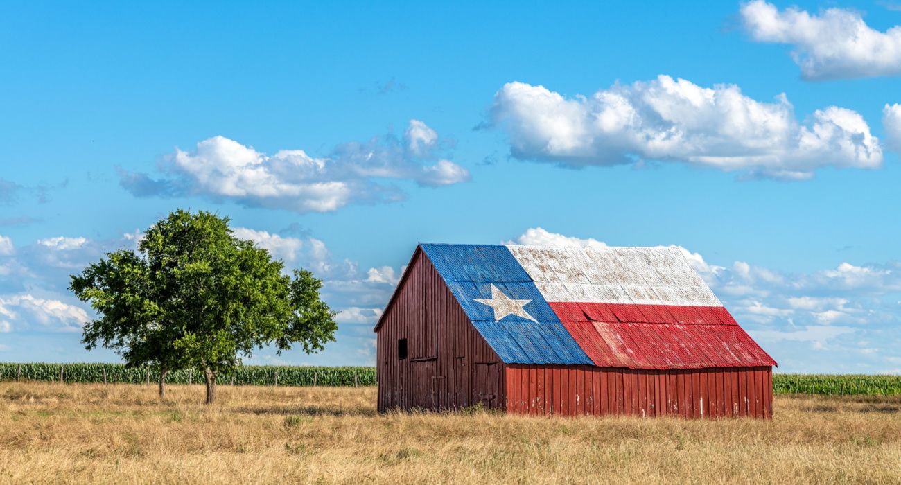An abandoned old barn with the flag of Texas painted on the roof