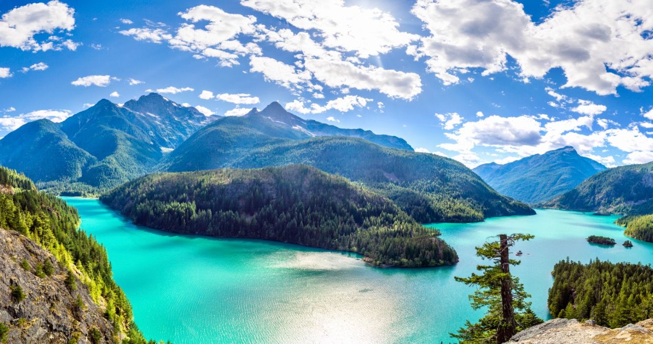 Panorama of a bright blue lake in North Cascades National Park.