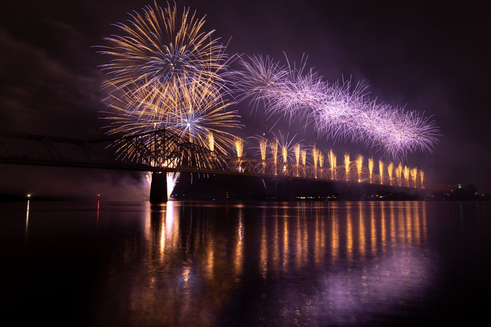 Fireworks on the George Rogers Clark Memorial Bridge and a river barge on the Ohio River, Louisville, Kentucky, USA