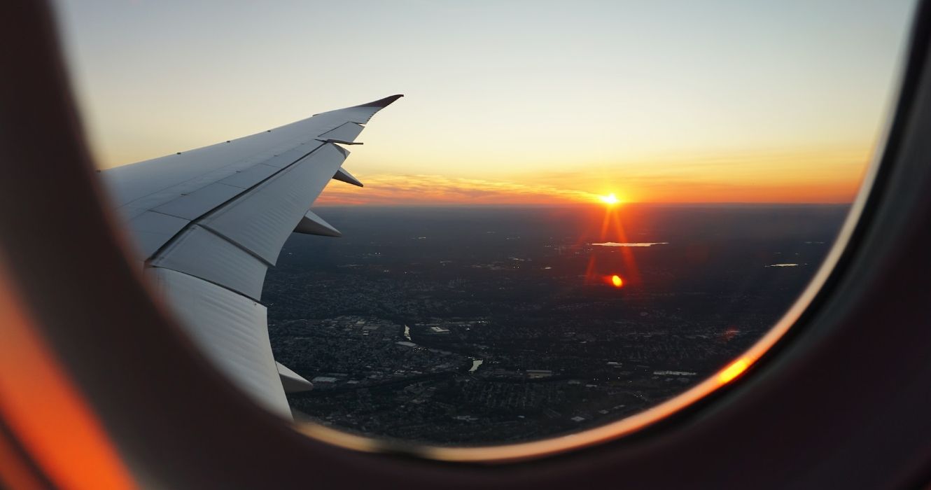 View out of an airplane window at sunset