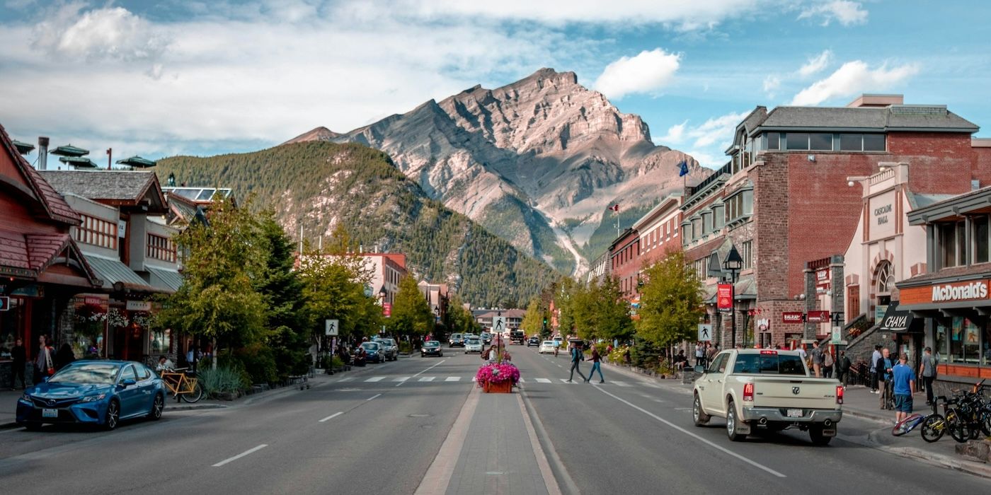 Cars and bikes parked on a road in Banff, AB, Canada