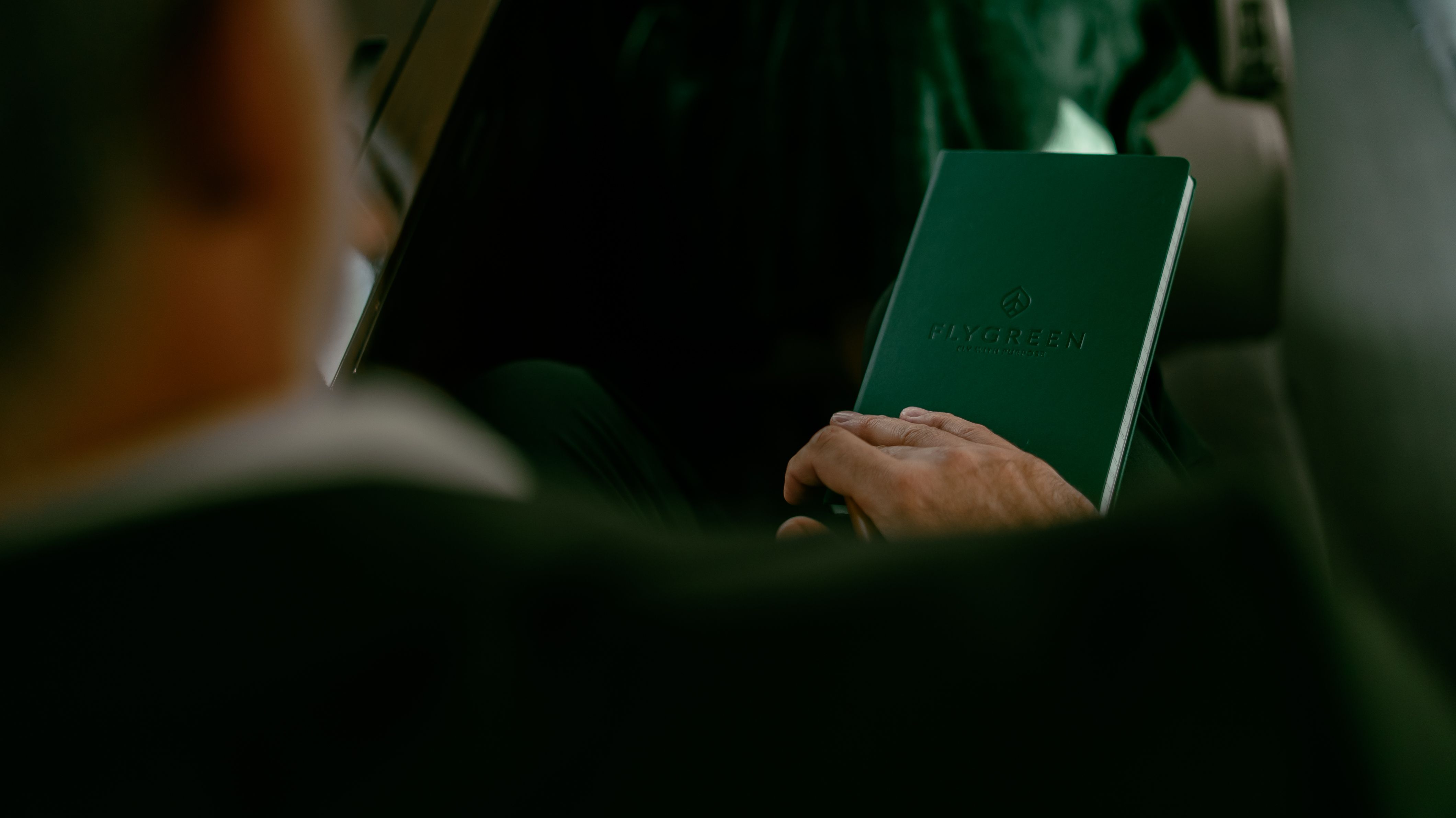 A client holds a booklet for private jet charter company, Flygreen