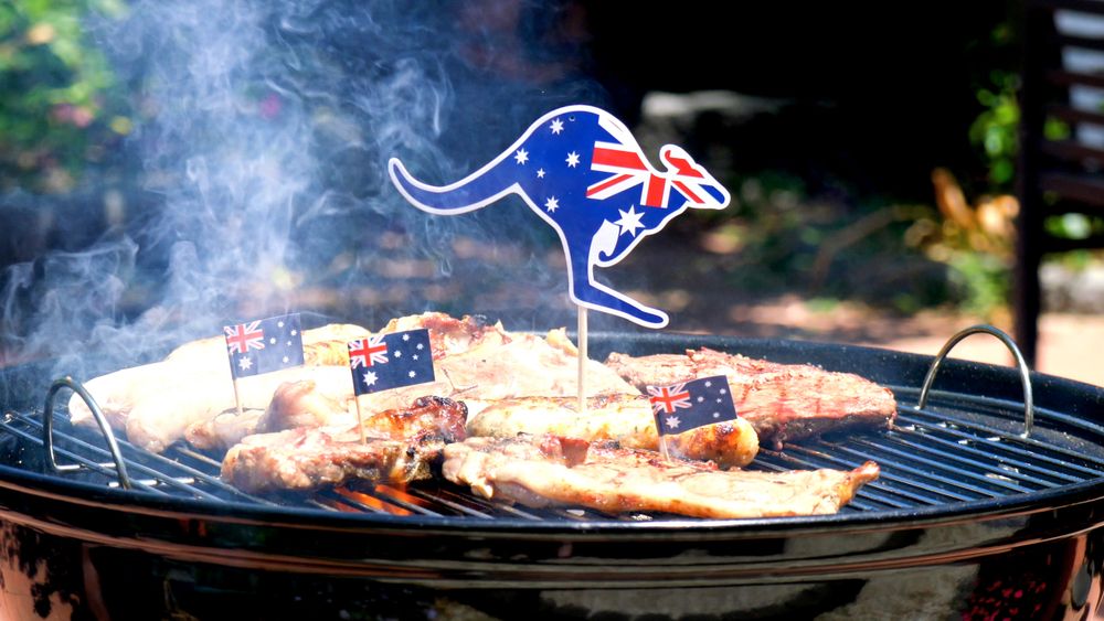 Iconic Australian BBQ close up of man cooking chops, sausages and steak