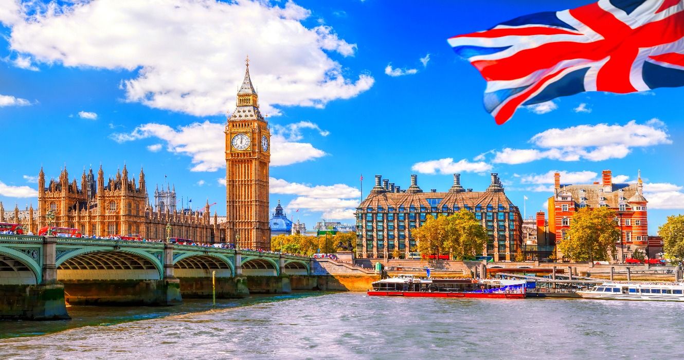 Big Ben seen by the River Thames with a flag of the UK (the Union Jack) in London, UK, United Kingdom