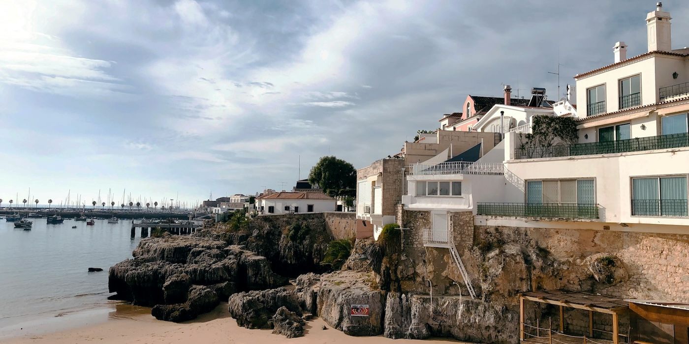 A sandy beach next to a body of water in Cascais, Portugal