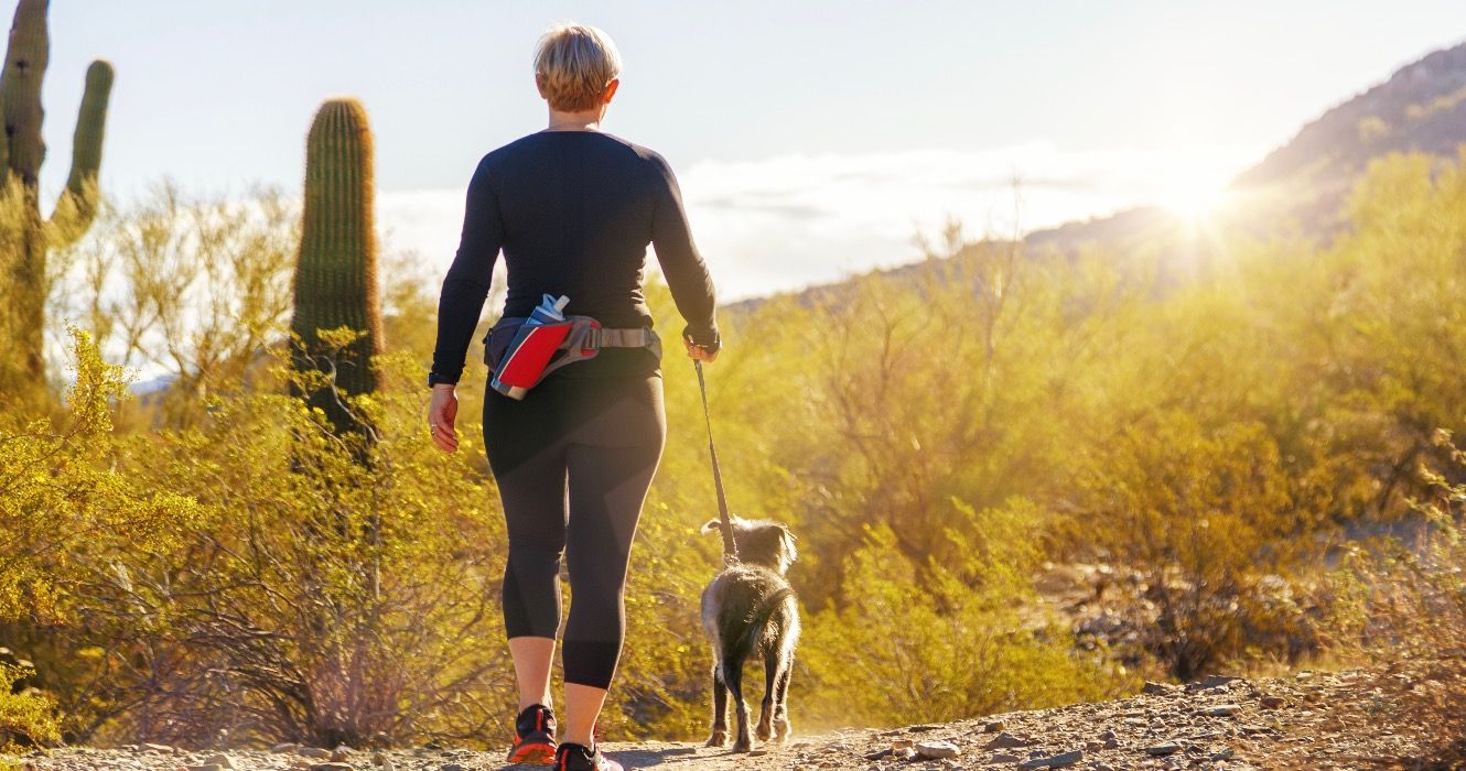Woman walking her dog, Arizona hiking trail