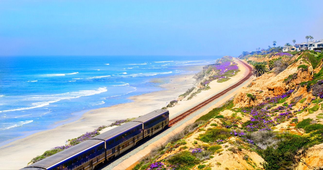 Amtrak train passing by beaches on the coast through San Diego, California, CA, USA