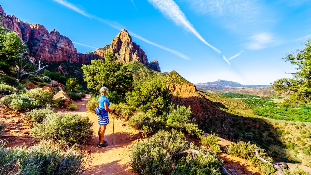 Woman hiking at sunrise on the Watchman Trail in Zion National Park in Utah,
