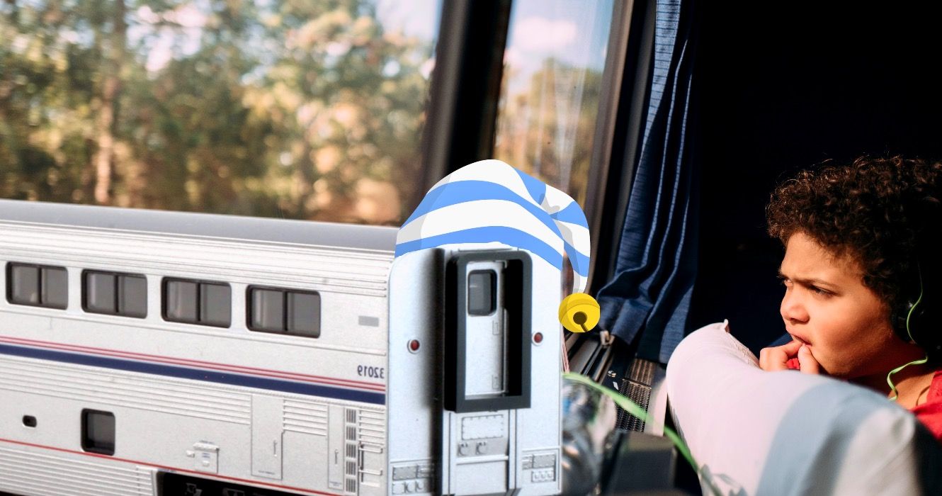 Young child looking out of the window with headphones on while on an Amtrak train car