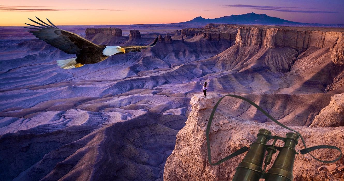 Woman at sunrise overlooking desert landscape in Hanksville, Utah USA