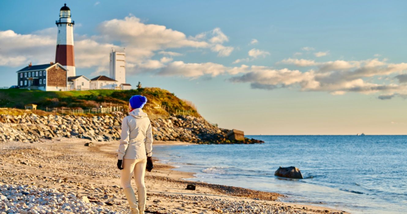 Woman tourist at the beach near Montauk Lighthouse, Long Island, New York, USA.