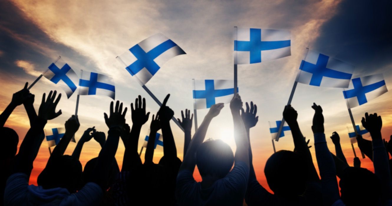 Silhouettes of People Holding the Flag of Finland