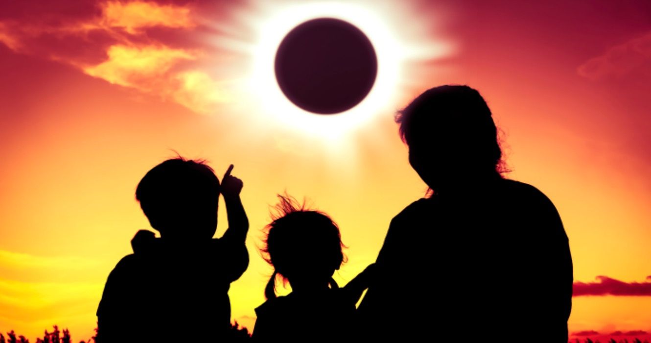 Family viewing solar eclipse at dusk