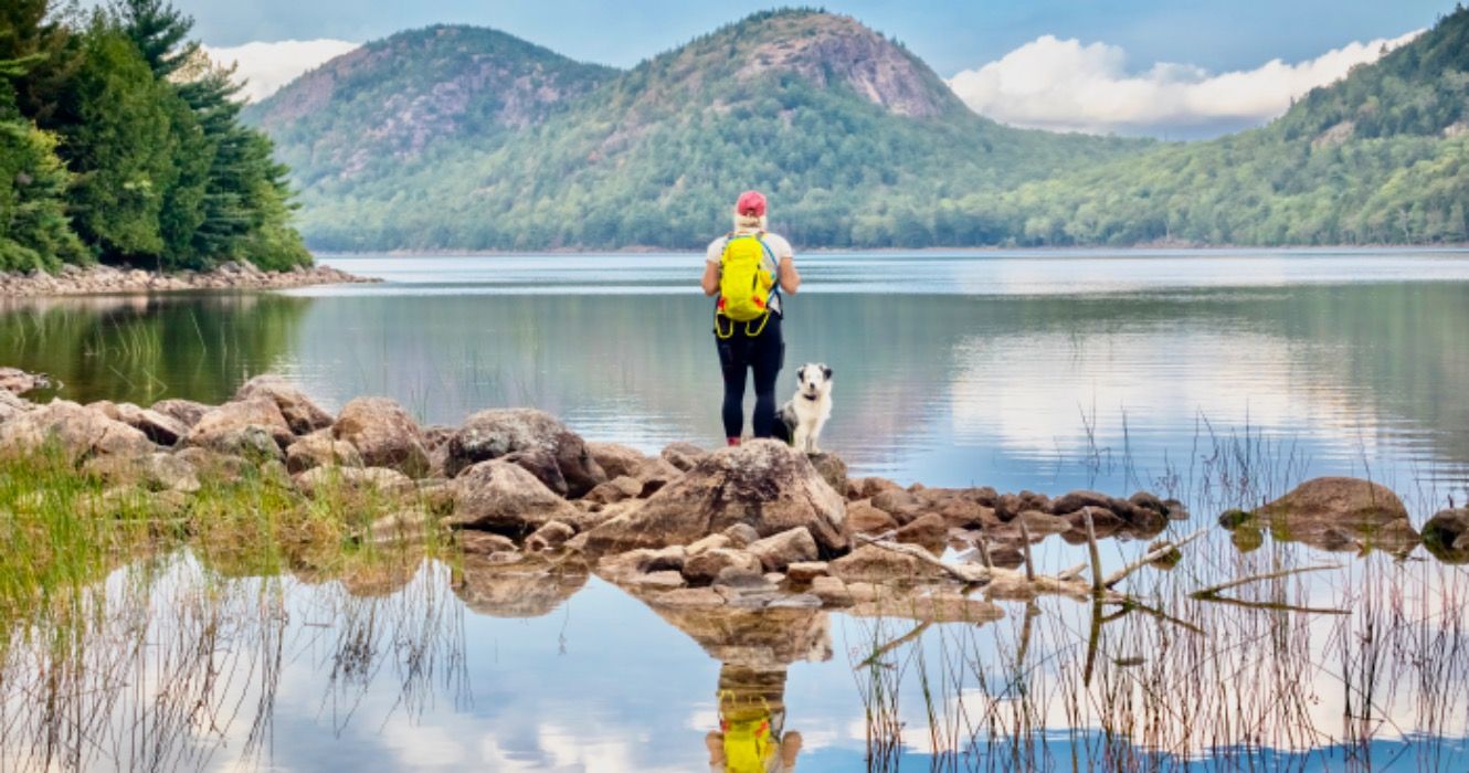 Female hiker and dog at Jordan Pond and The Bubbles, Acadia National Park, Maine