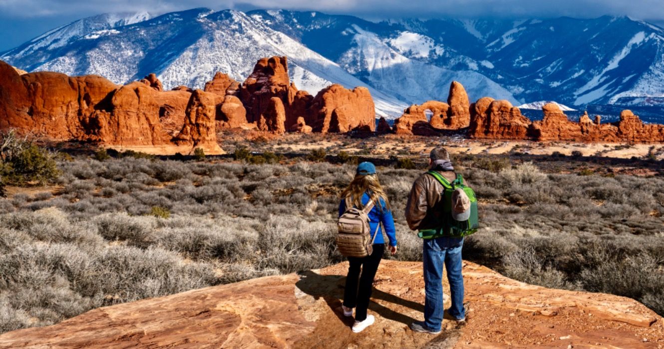 Couple enjoying beautiful mountain view on hiking trip in Utah.