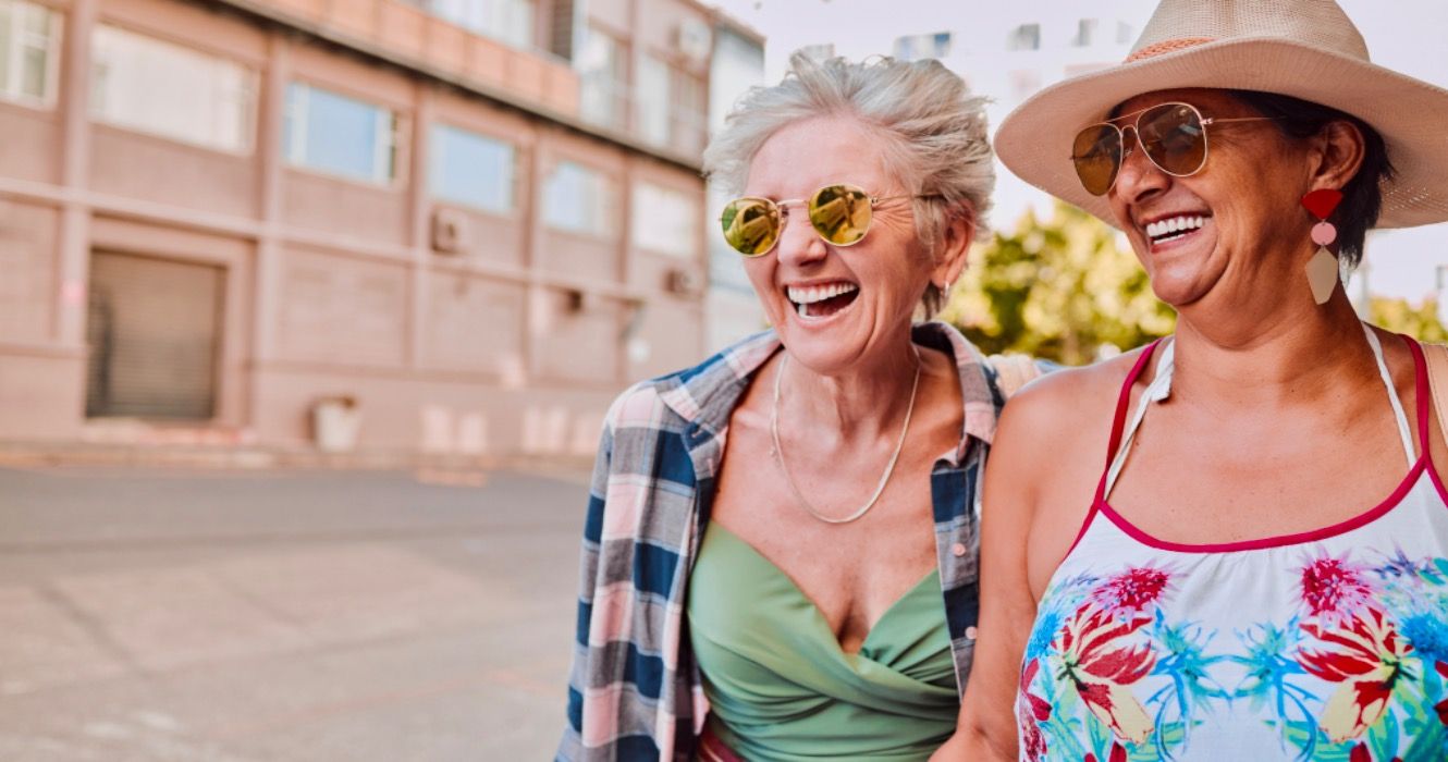 Two retired women smiling while on vacation 