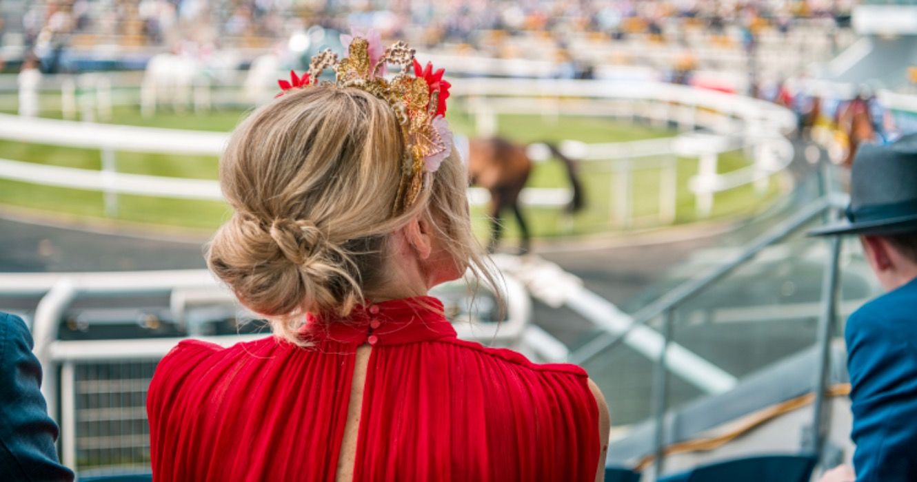 Woman in red watching horse race 