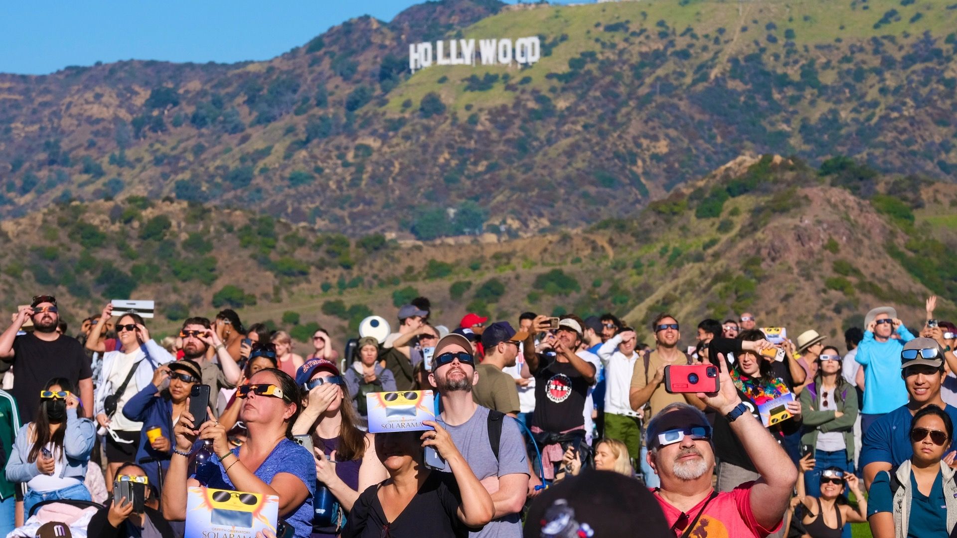 Solar enthusiasts view a partial solar eclipse through special protective glasses at the Griffith Observatory