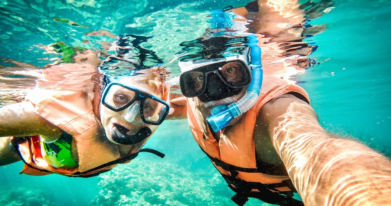 Retired couple snorkeling in tropical waters