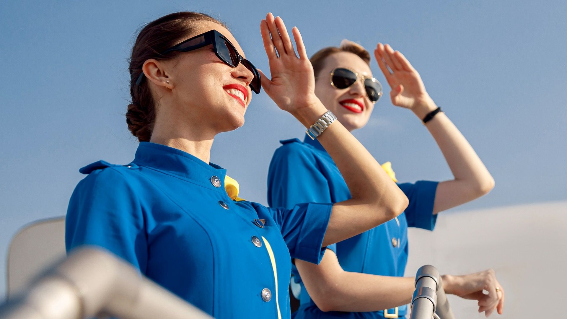 Flight attendants pose outside in uniform 