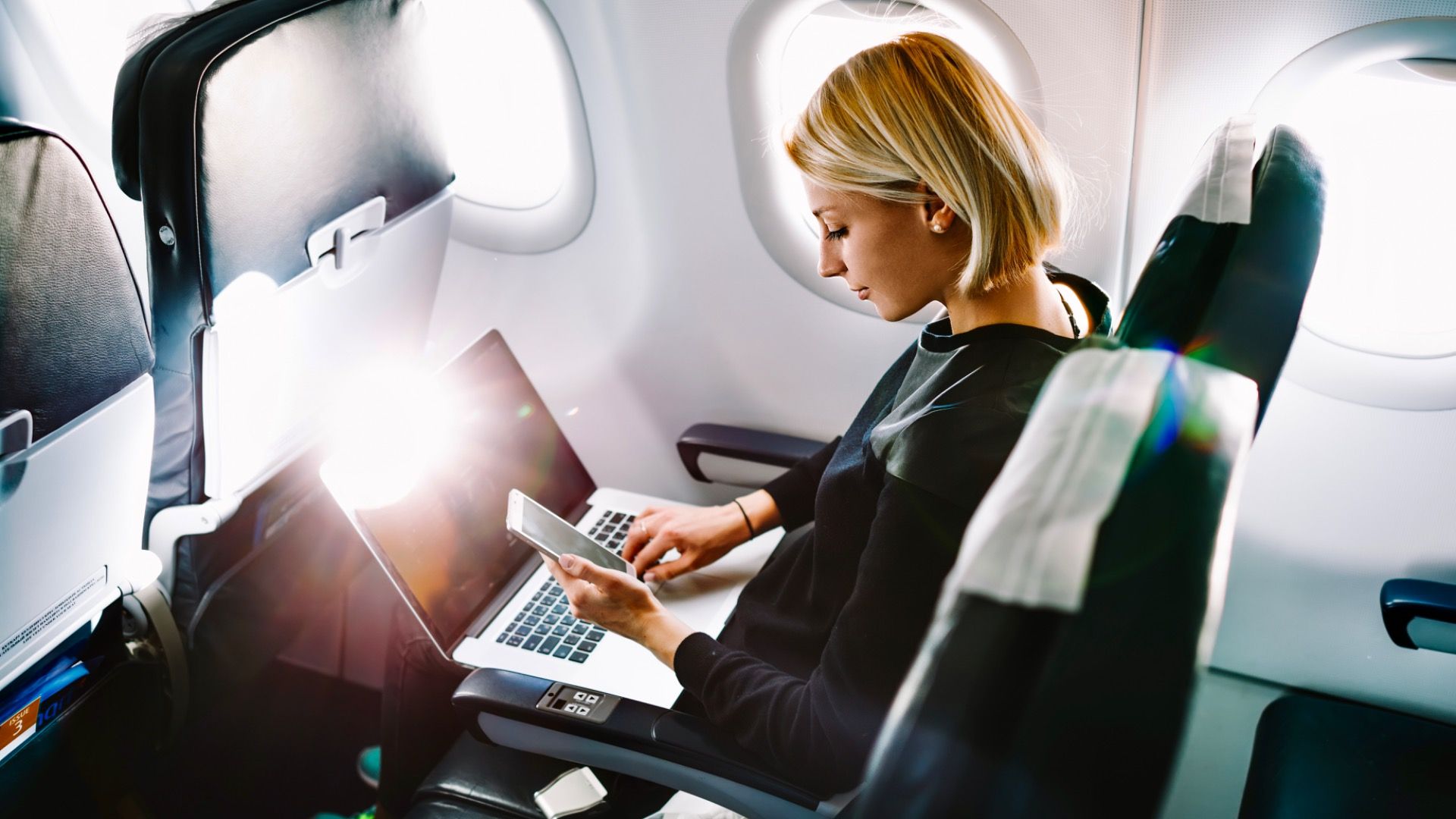Young woman sitting in business class on airplane 