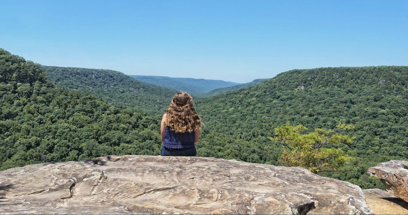A young girl enjoys the mountain views from Buzzard's Roost Overlook in Fall Creek Falls State Park, Tennessee