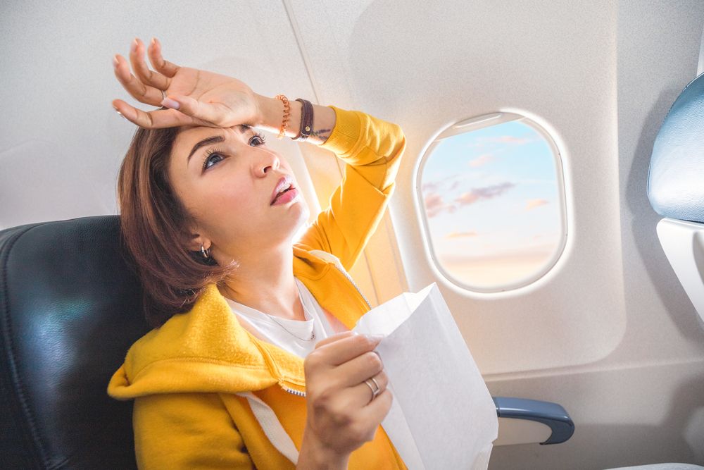 A female traveler suffering from nausea on a plane