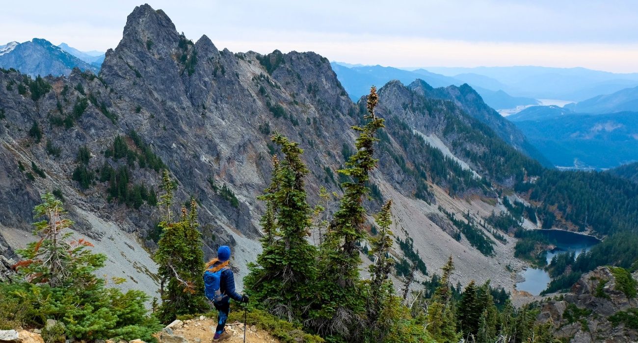 Woman Climber Looking Towards Mountains and Lake