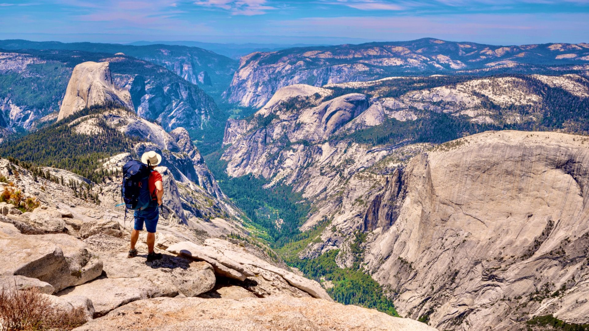 Backpacker on top of Clouds Rest looking down into Yosemite Valley