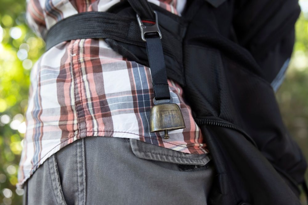 A hiker with a bear bell on their belt