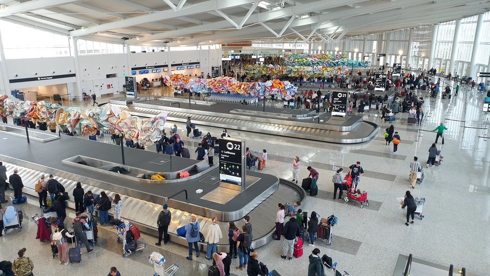 Crowds of people waiting at baggage claim inside Seattle airport terminal, Seattle