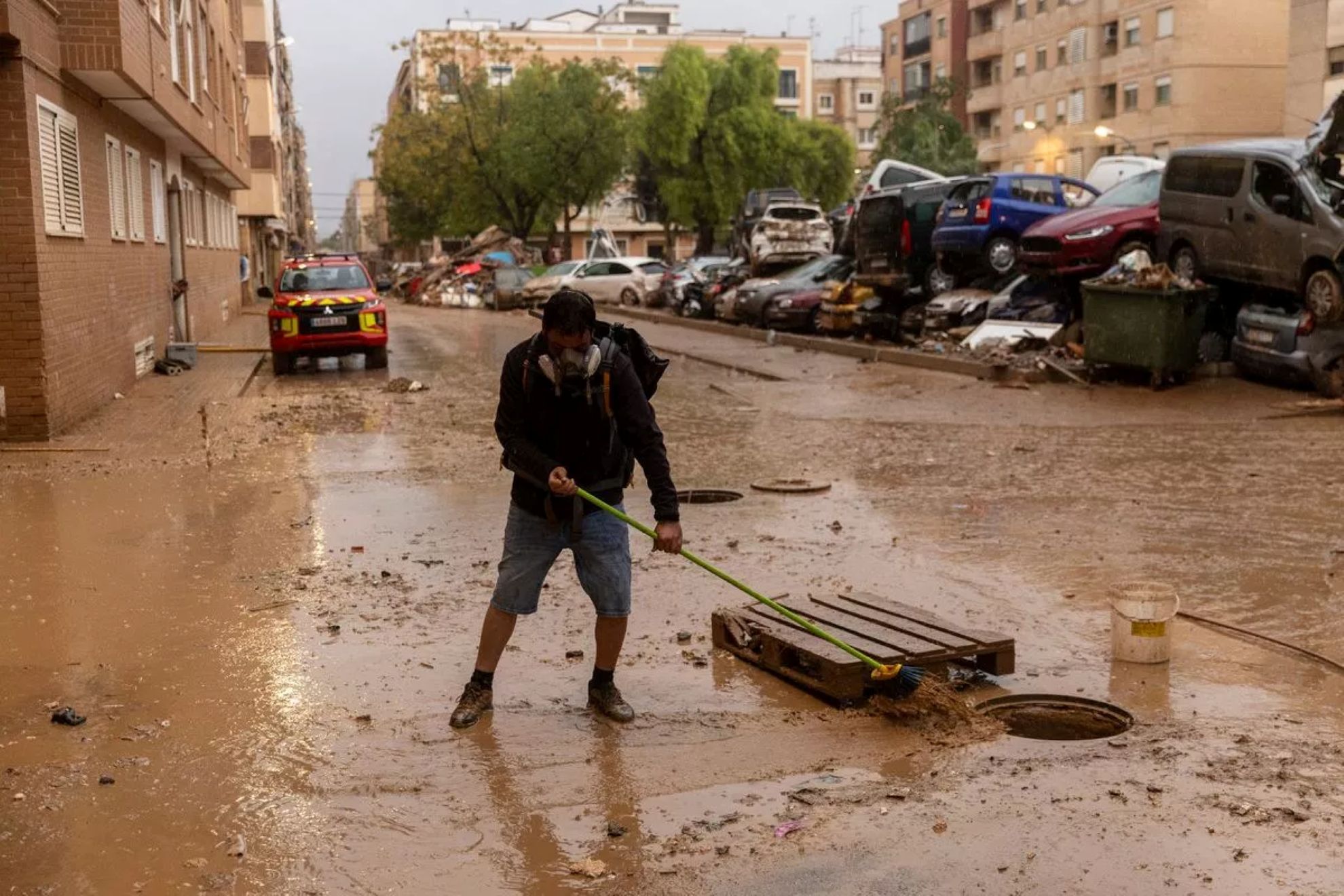 A man clears mud from the street during a flash floods in Valencia, Spain - Getty images