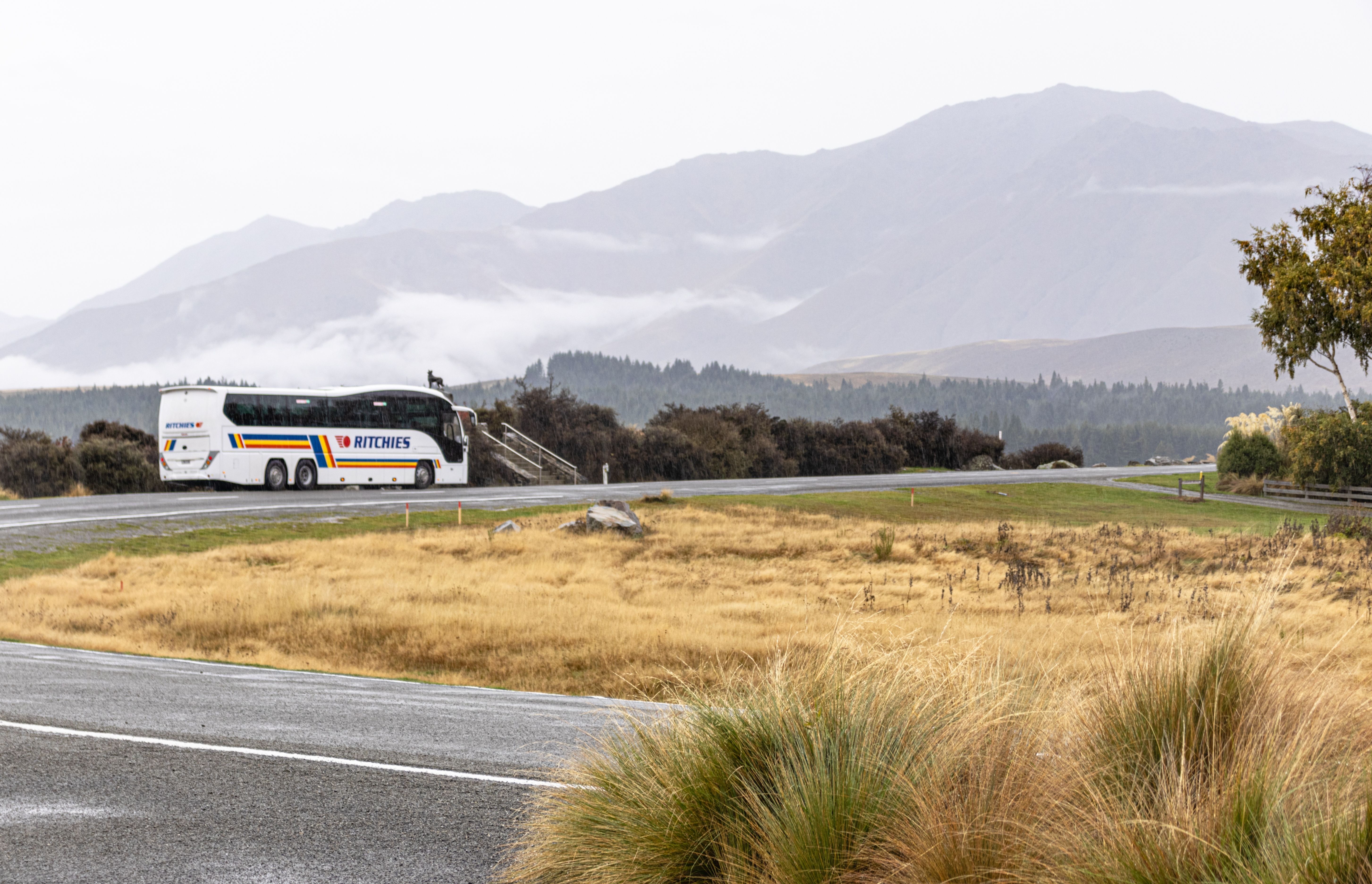 A Ritchies Tourist Bus parked at Lake Tekapo in New Zealand