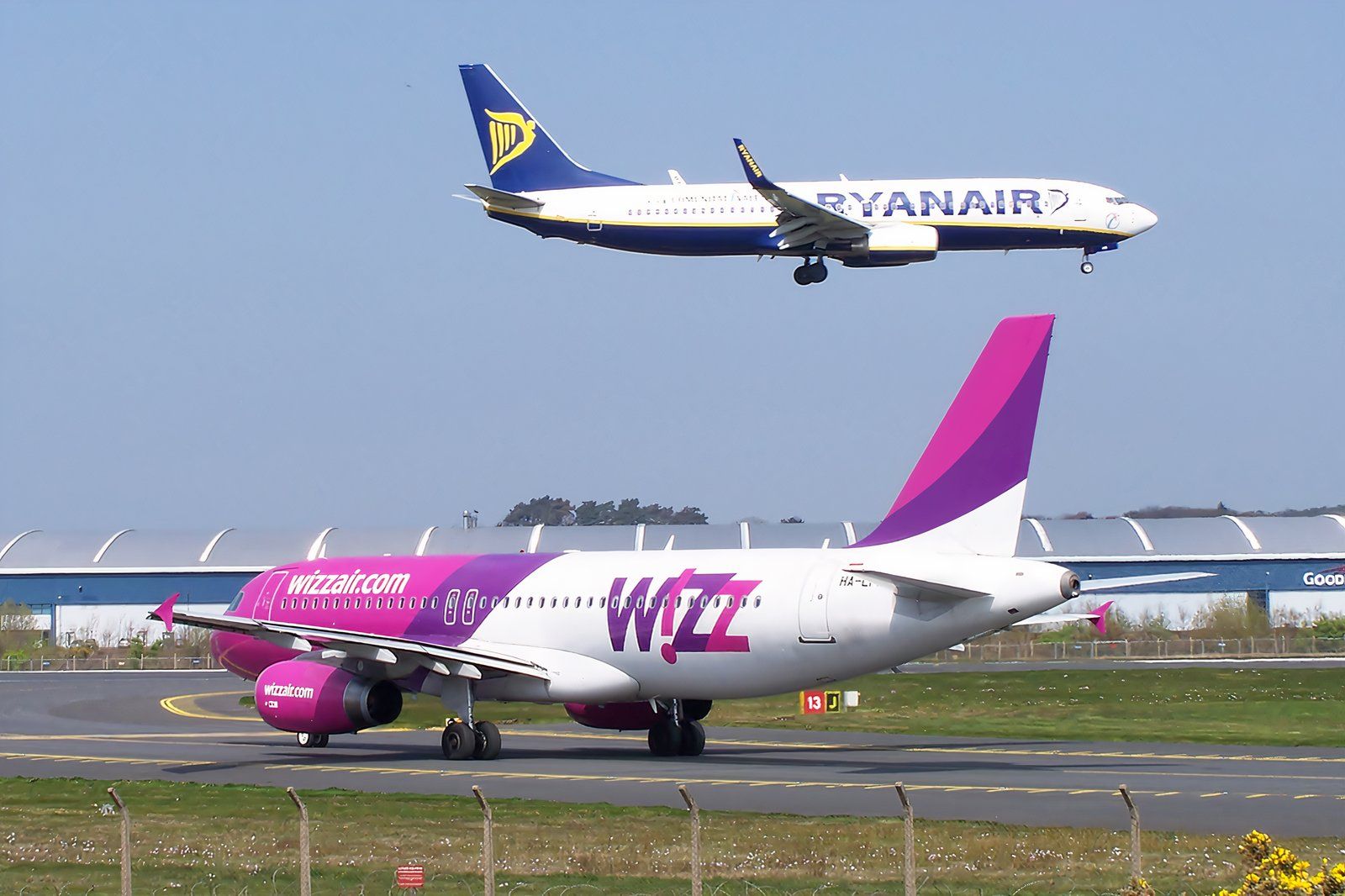 Ryanair 737 landing, while Wizz A320 waits at the holding point