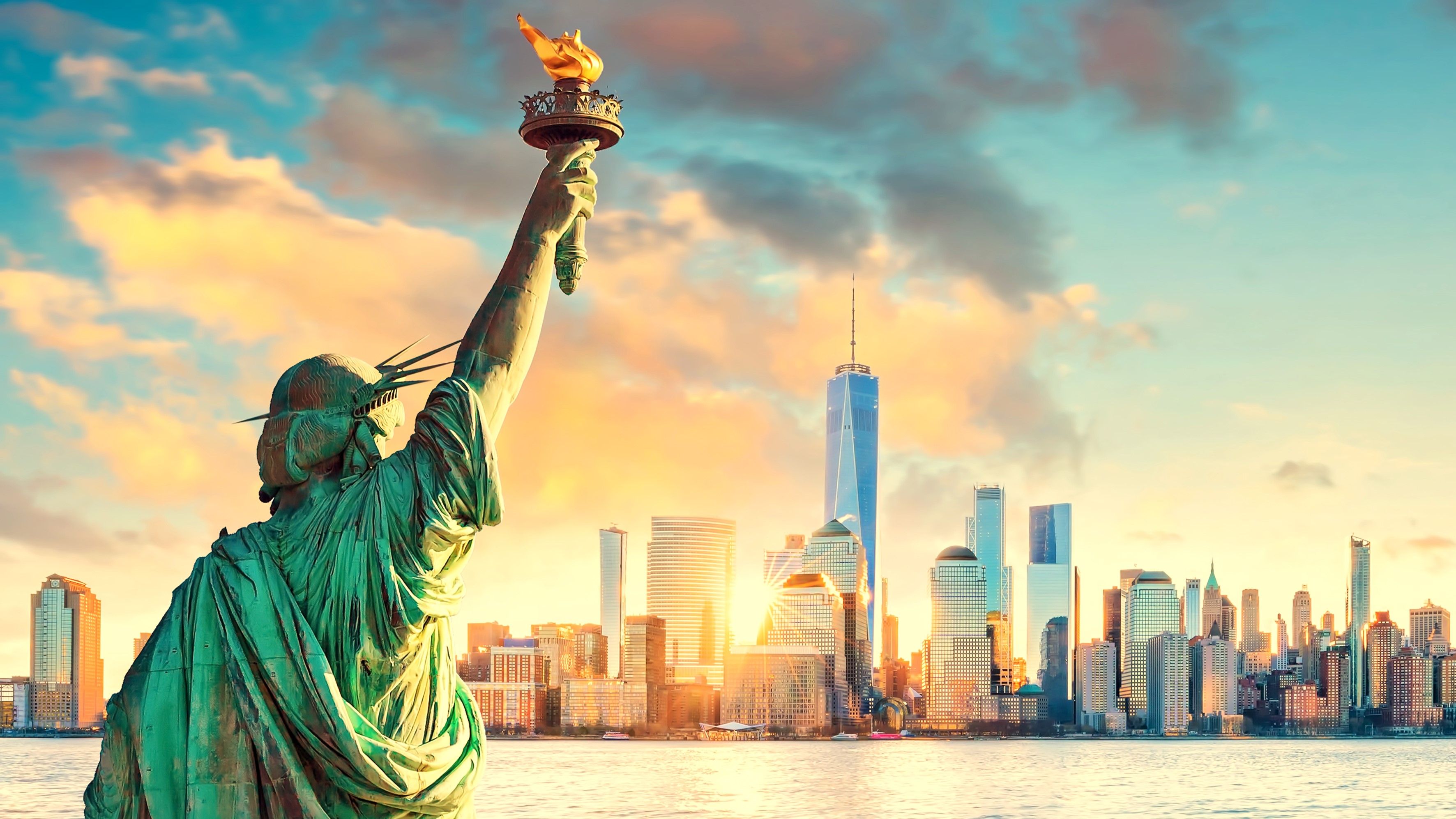 Statue⁣ of Liberty and New York City skyline at ⁤sunset