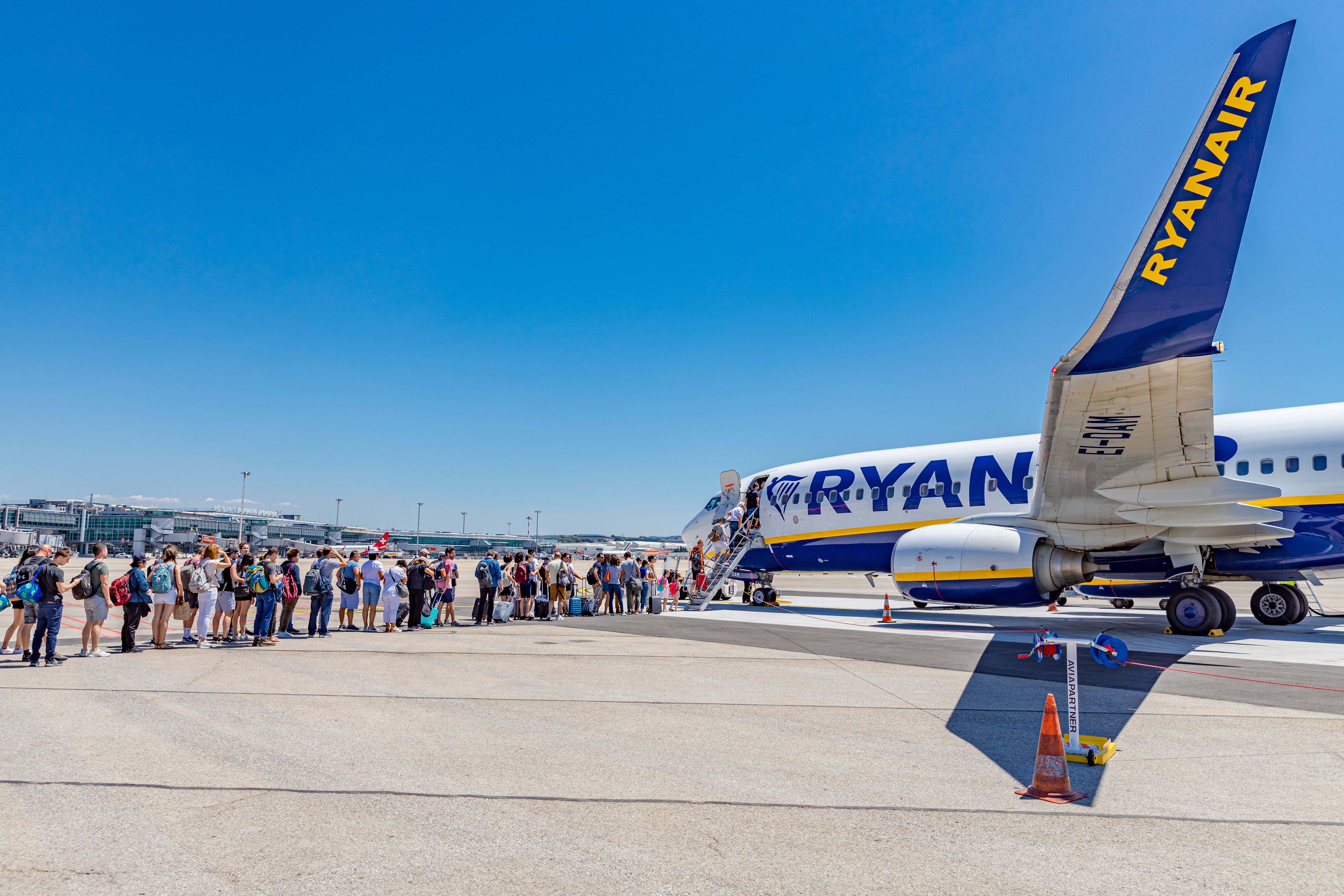 Passengers boarding Ryanair flight from France to Italy on a sunny day