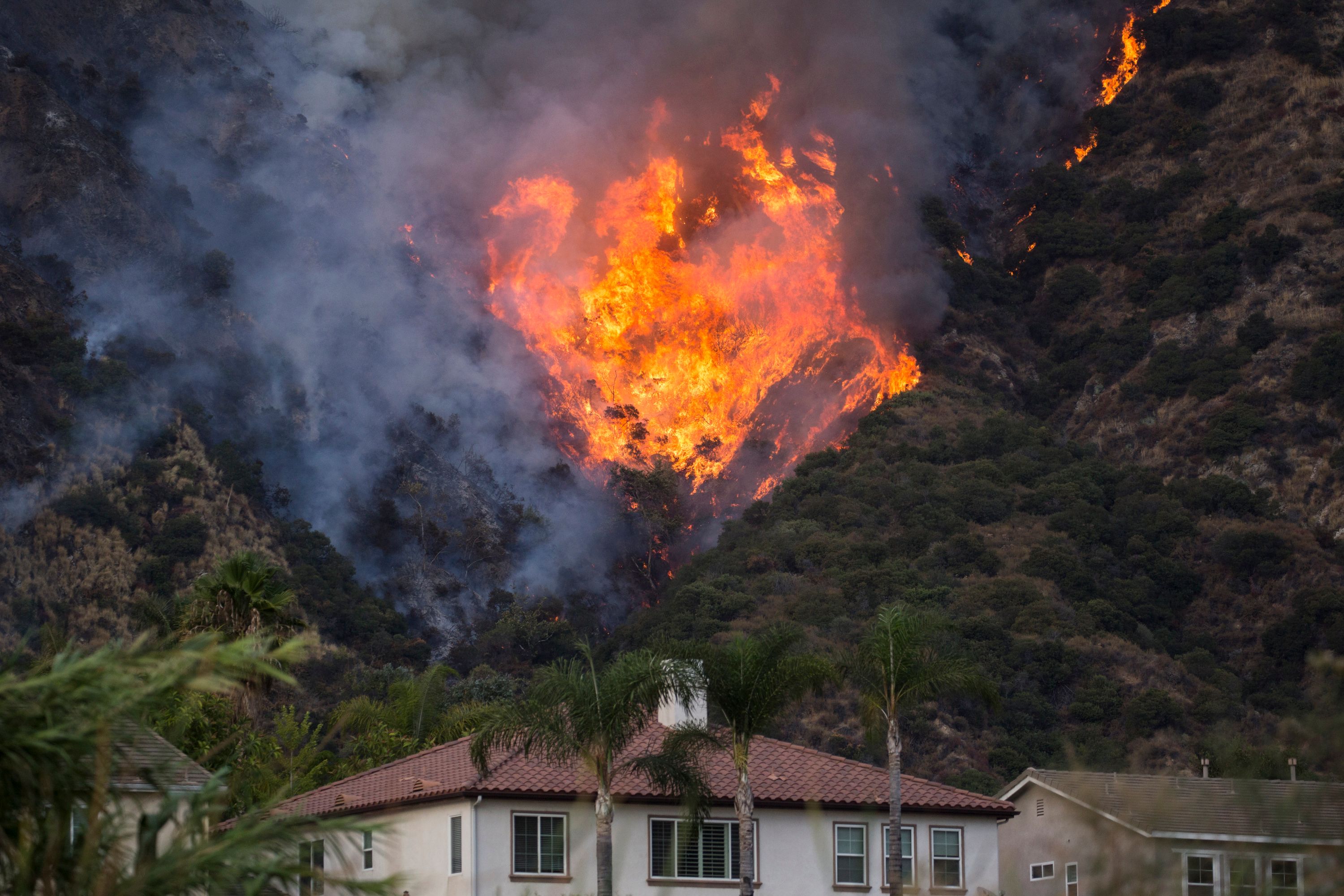 Hill on fire behind home in Southern California