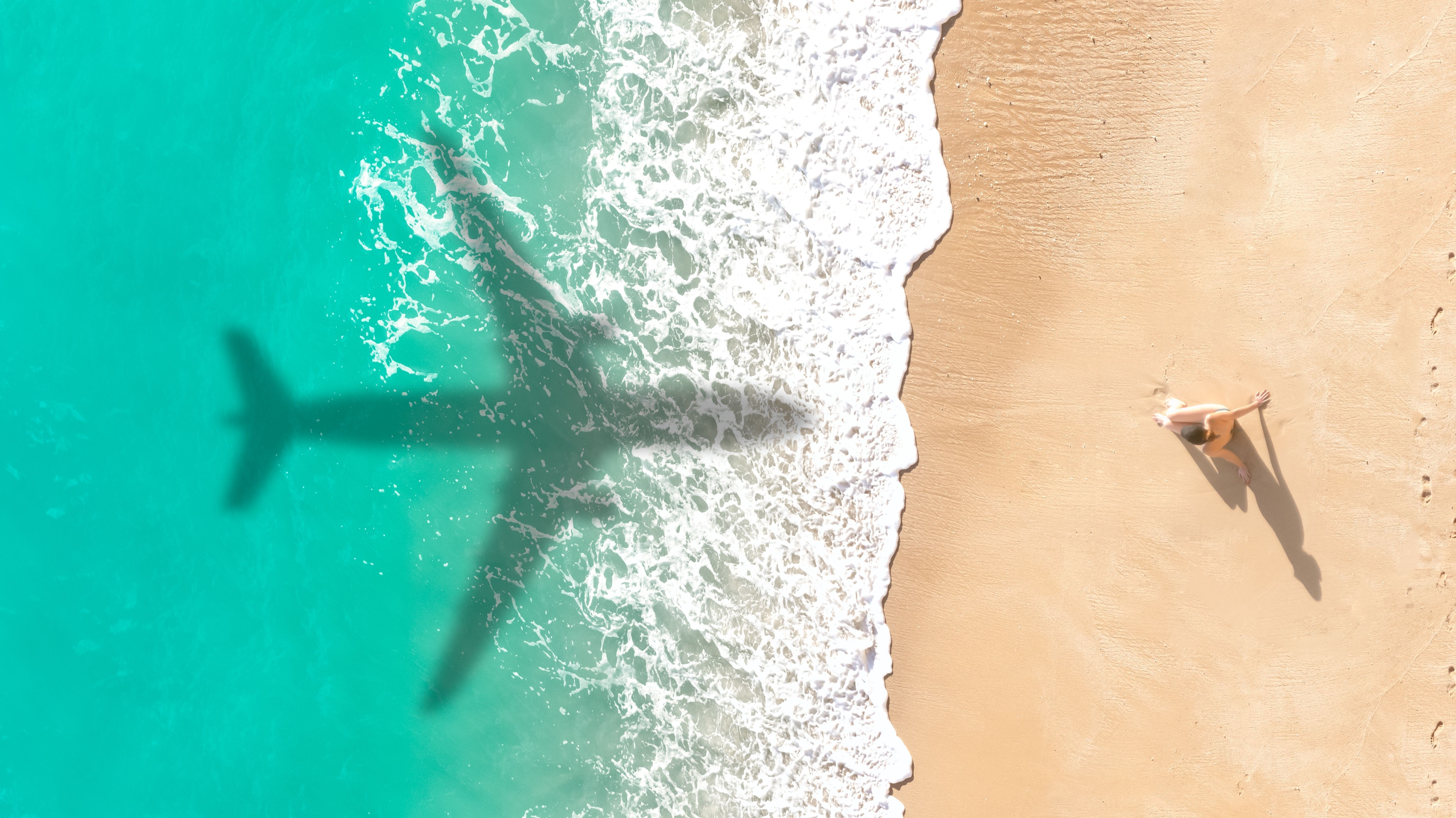 Shadow of an airplane over a beach in the Bahamas