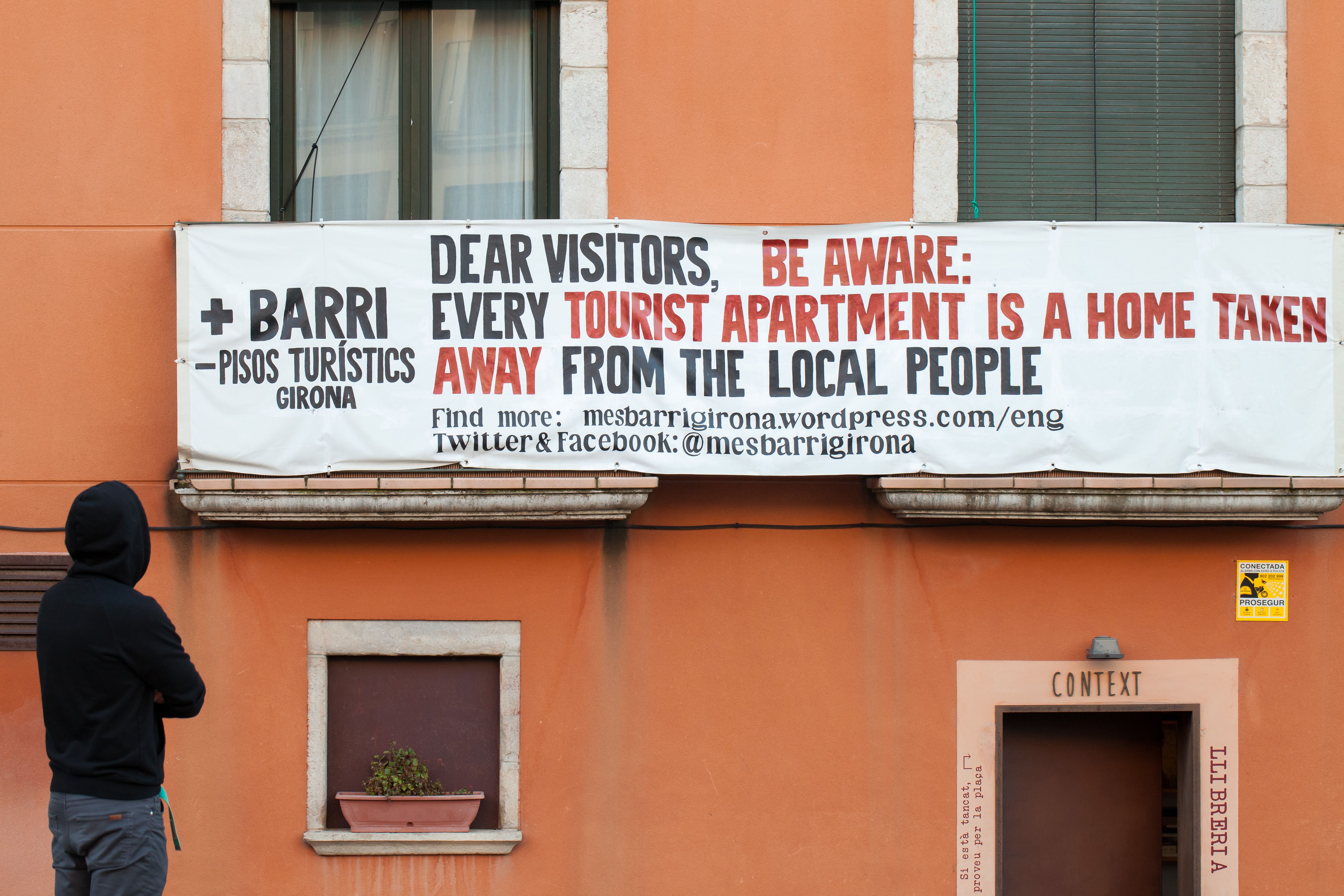Signage in Girona, Spain warning tourists about resident's housing crisis thanks to vacation rental purchases