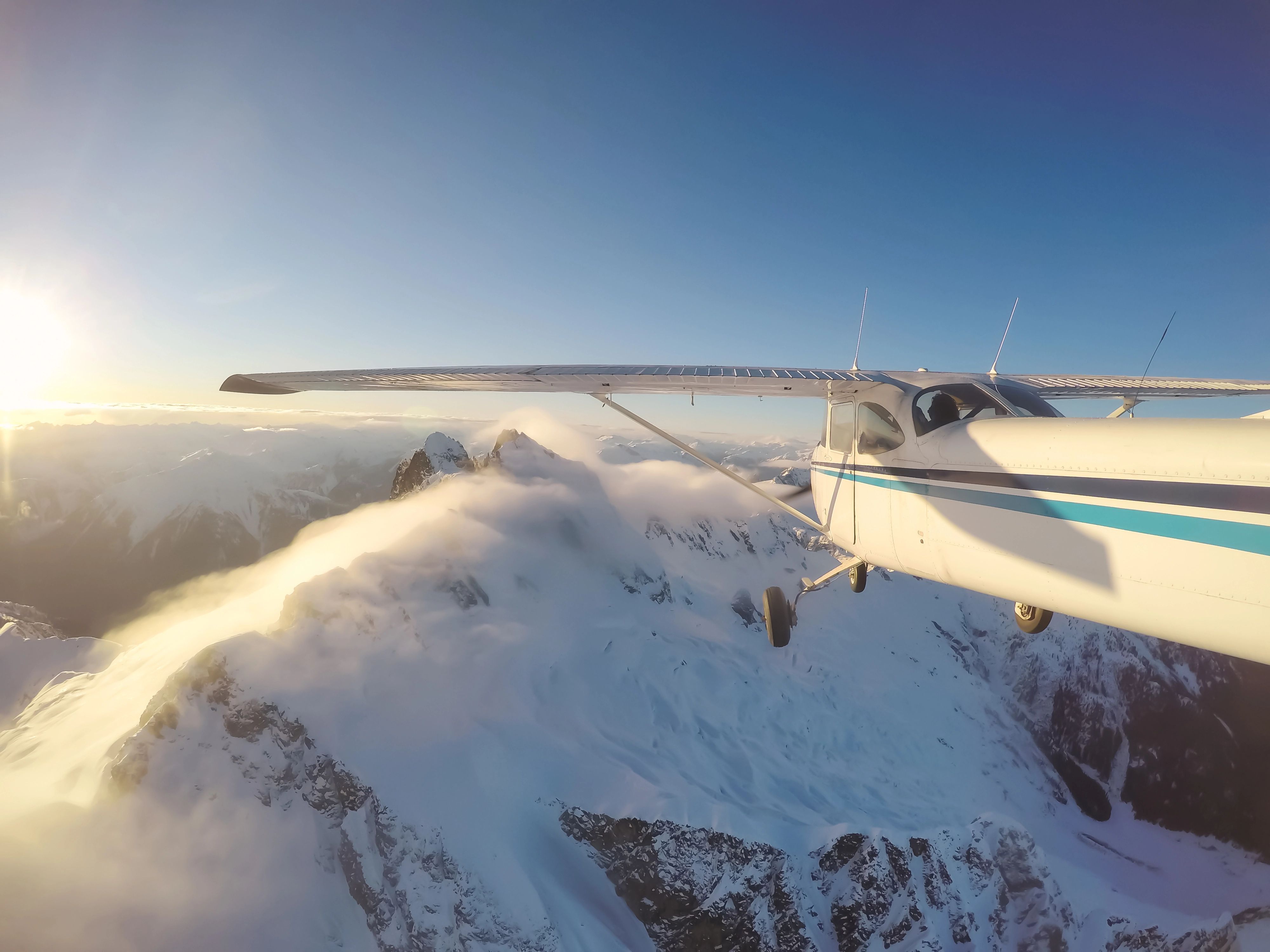 Small plane flies toward snow -covered mountains