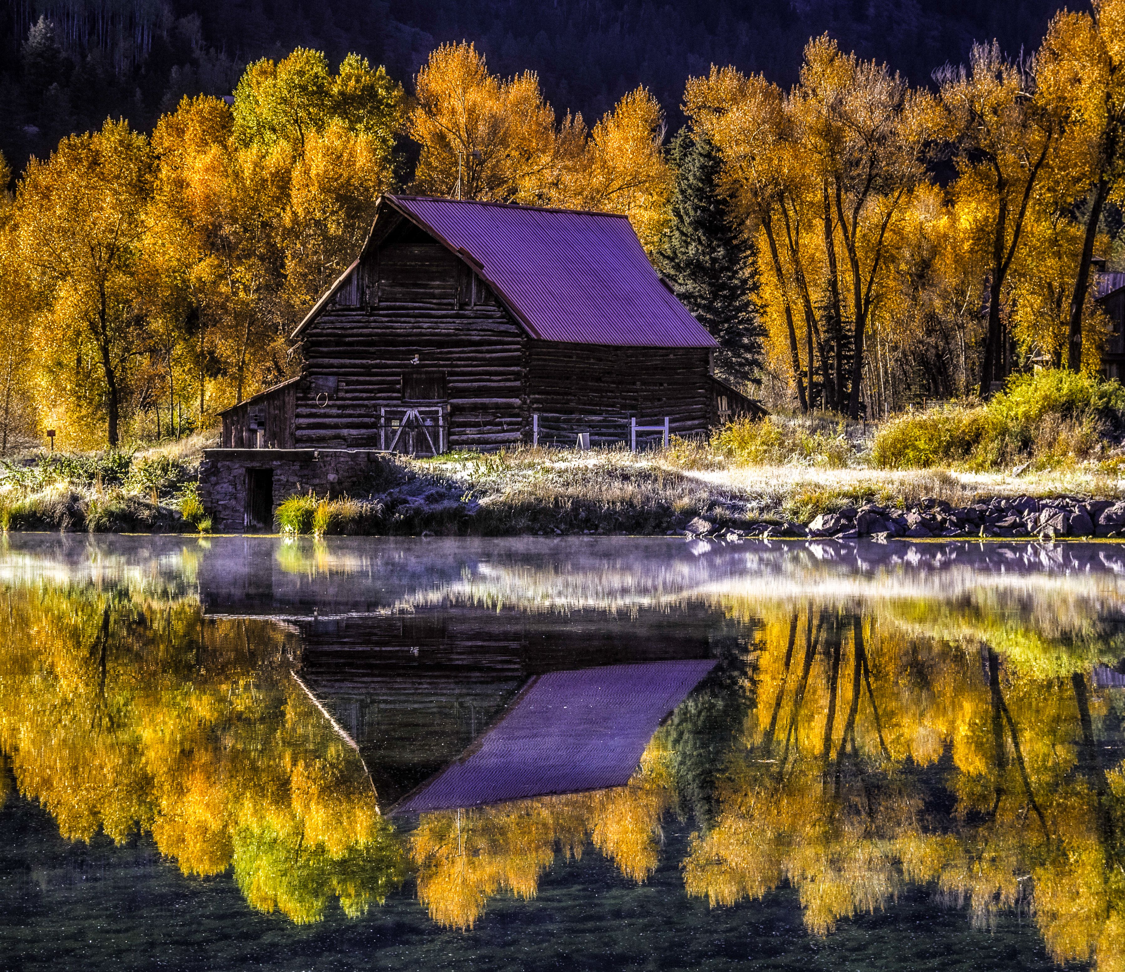 Lake City Colorado. Reflection of an abandoned barn in mountain lake on frosty fall morning
